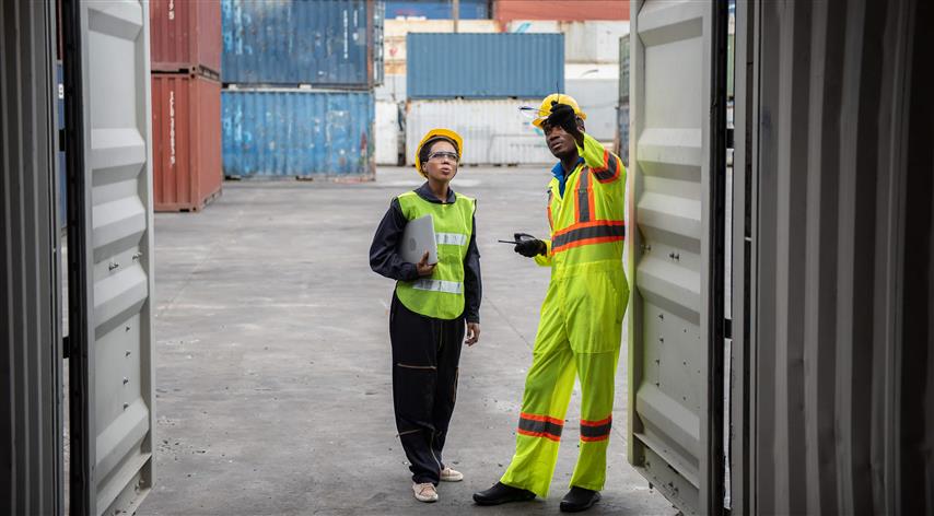 man trains young woman at container terminal